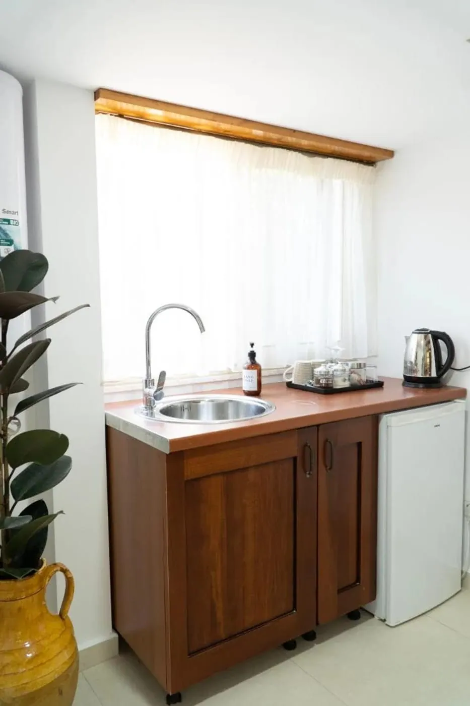 Walnut kitchenette with a terracotta jug and a potted plant